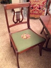 Double pedestal, 3 leaf table with 5 harp back, needlepoint cushioned chairs and 1 captain chair. Matching needlepoint seat covers in a delicate floral pattern.