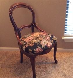 Curved wood chair with floral cushion