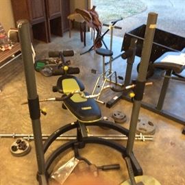 Weight bench comes with barbells, dumbbells, leg attachment, poles and securing hardware.