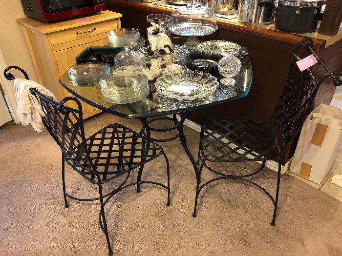 Very nice glass top table with wrought iron base and to wrought iron chairs