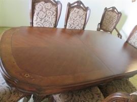 Sculpted Oval Shape of the Dining Room Table Top with Inlay Details at the 4 corners