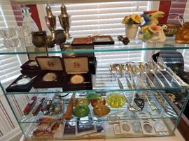 Sterling spoons, fork, hand-blown glass eggs, Vaseline glass flower frog, pocketknives, 90% silver coins, Uncirculated & boxed silver dollars, fishing lures
