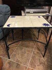 There are 2 of these iron and ceramic tables available.