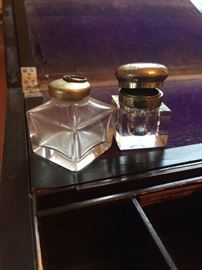 Two of the three glass bottles inside writing desk, one is inkwell