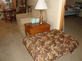Large ottoman, stuffed chair, end table. table lamps, tea cart