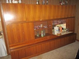 Danish Modern wall unit with a drop down bar and storage from top to bottom. Three pieces. Teak veneer purchased in Germany in 1969. We can provide resources to help move it!