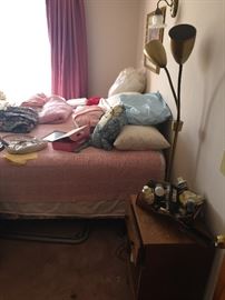 Queen Sized Bed with various bedding.  There are a pair of the mid-century modern nightstands and a dresser to match