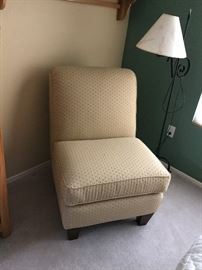 Upholstered chair and wrought iron floor lamp