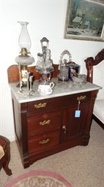 WALNUT AND MARBLE TOP WASHSTAND. SILVER PLATE CASTER SET, SILVER PLATE PICKLE CASTER, PORCELAIN HUMIDOR. KEROSENE LAMP.