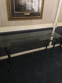 Glass top, wrought iron leg sofa table,  approx 52 inch length  17 inch wide and 28th ht