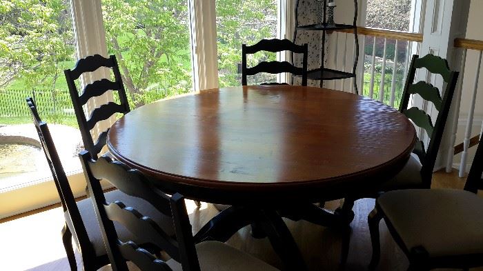 5' round wooden kitchen table and 6 chairs. Top is natural wood color and sides and base are black.