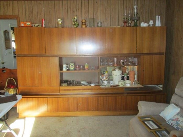Mid Century Modern teak veneer bar unit.  About 14 feet long, with storage on top, middle and bottom.  The bar is a drop down piece.  We can assist with moving.