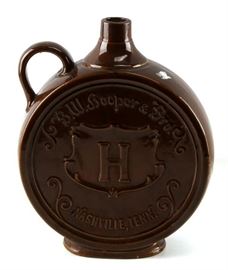 Antique B W Hooper Stoneware Canteen Whiskey Jug Nashville Tennessee | Jug has raised lettering of "B.W. Hooper & Bro. "H" Nashville, Tenn. | This is a remarkable stoneware canteen whiskey jug with no chips, cracks, or crazing | No other markings | Very good to excellent overall condition. Very Impressive display piece | Measures 13" H X 10" Dia. X 3.75" D.
Dimensions: 13" H X 10" Dia. X 3.75" D
Artist or Maker: B W Hooper & Bro.
Medium: Stoneware
Date: 19th Century
Condition Report: This is a remarkable stoneware canteen whiskey jug with no chips, cracks, or crazing | No other markings | Very good to excellent overall condition. Very Impressive display piece.