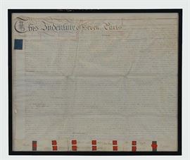  A beautifully-preserved 1792 handwritten British indenture on vellum. Though most indentures of this time period were legal contracts binding indentured servants, this particular piece seems to be the will of a man named Charles Cotton. A blue cypher seal from the reign of King George III sits in the upper left corner. The piece is written on vellum from the “Stationary Office, Palace Yard.” Signatures and wax seals depicting the busts of each signee, including Cotton, are lined up across the base of the page. All seals are still intact on the Indenture. A wavy line is cut across the top of the page; this is because these documents were written in duplicate on the same sheet, separated by cutting along a jagged (toothed, hence the term “in_dent_ure”) line, then lined back up together to ensure authenticity. The indenture is presented behind archival glass double glazed in a thin black wooden frame. A wire is attached to the verso of the piece for hanging. Document is in Very Good cond