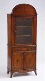  Antique Federal Curio Cabinet | The cabinet has an arched pediment with a starburst design surmounting a glass paneled door opening to two shelves, the bottom with two drawers over double doors opening to additional storage, all raised on French bracket feet joined by a serpentine apron. Dimensions: 71.5"h x 28"w x 14.5"d.
Dimensions: Dimensions: 71.5"h x 28"w x 14.5"d
Medium: Mahogany