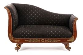 Antique American Second Empire Mahogany Recamier | Mid - 19th century | A Second Empire style mahogany recamier, having an upholstered sloping shaped seat back with a rounded crest rail, with scrolled arms, one dropping to form a foot rest, the seat rail and arm supports carved and mounted with foliated gilt ormolu, on scrolled legs. Upholstered in black fabric with gold fleur-de-lis. Approximate height 36", width 56", seat depth 18", seat to floor 17".
Dimensions: height 36", width 56", seat depth 18", seat to floor 17".
Date: 19th Century