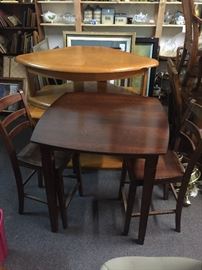  A wooden bar height table with two chairs. It's a little rough and could use paint or refinishing. 