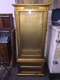 China cabinet tall and narrow. Gold gilded and has glass shelves. Lighted
