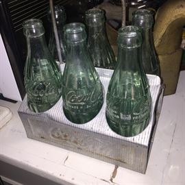 Vintage Coca-Cola bottles in a aluminum carrier.
One marked on the bottom 2 Dallas Texas, 2 Fort Worth Texas, 1 Houston Texas and one with no markings on the bottom