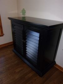 Black 2 door cabinet with one drawer and two shelves inside