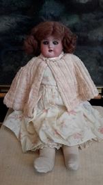 Vintage porcelain head doll with leather body and hand painted moving eyes.