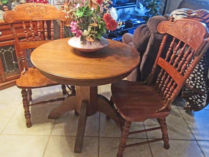 Small round oak table and a pair of ornate oak side chairs