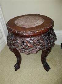 Oriental carved stand with marble inset.  There are several of these throughout the home