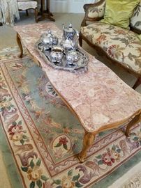 Marble top long coffee table on Chinese sculpted rug. Silverplate tea set on table.