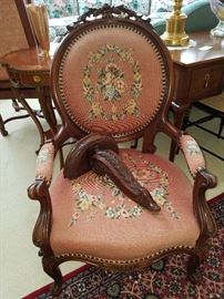 Needlepoint upholstered arm chair.  On seat is a bracket (shelf) for interior use