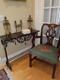Cast iron table with marble top, displaying 3 piece brass and prism garniture.  