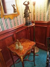 Carl Forslund pedestal displaying a patinated metal figural sculpture.  Foreground is an inlaid square-form table with ormolu mounts (one of a pair)