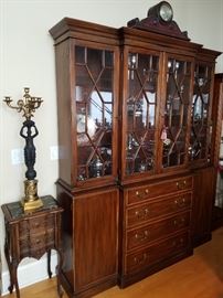 Impressive breakfront from a Virginia company.  Displays some of the silverplate hollow ware collection.  Small stand to left is carved and has inset marble top.  Figural candelabrum on top appears to be French