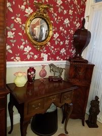 Corner Mahogany stand (One of a pair) displays Mid-20th Century reproduction of a Ca. 1800 knife box. Low boy stand displays decorative items.  On the wall, an eagle crest convex mirror