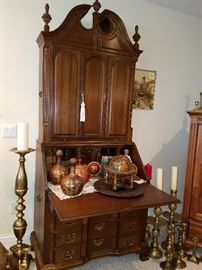 Broken arch top secretary with triple arch door, slant front writing surface, and lower drawers.  No label found, but good quality.