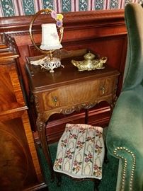 Ornate one-drawer stand, Upholstered foot stool. Another lamp with porcelain floral accents.  I think there are 4 of those lamps in various styles in this Library/Den