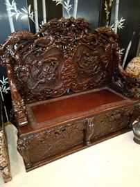 Carved oriental bench in a dragon motif.  Seat lifts for storage