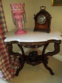 Ca. 1860 Turtle-top marble top walnut table with carved fruit bowl on stretcher.  VERY unusual. Nice example.  On top are a single luster, and an early battery operated clock that is non-functioning