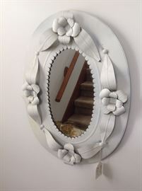 Oval wall mirror, formed from metal.