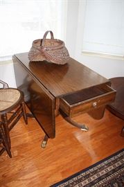 Showing walnut drop leaf table with drawer