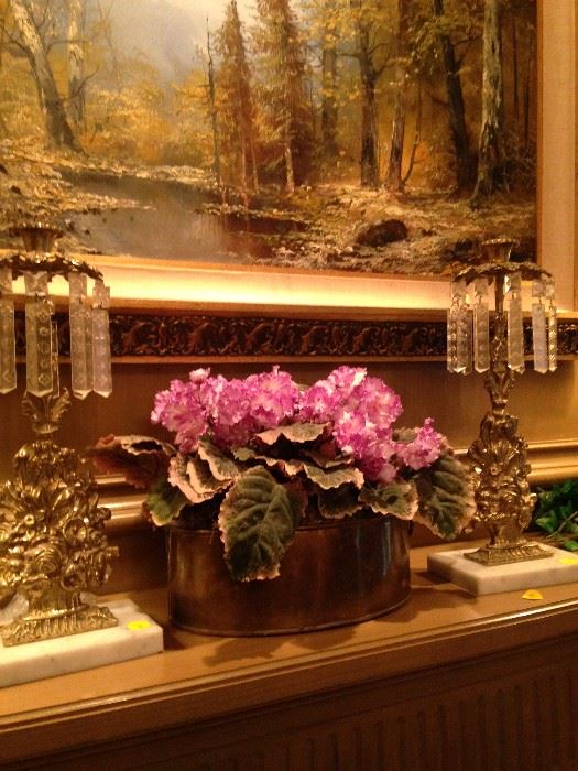 Antique lusters and floral arrangement; framed scenic view