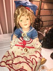 Shirley Temple doll with extra dress on a Shirley Temple hanger. Also includes to pinbacks 