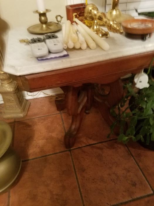 Marble top table. Lots of candles, brass, and crystal candlesticks.