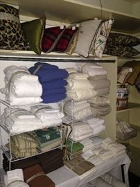 Many linens and decorative pillows