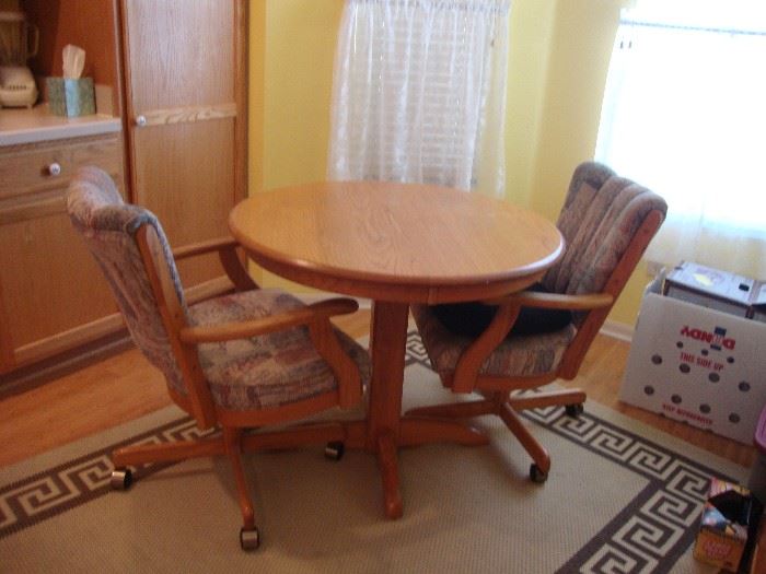 Small wood pedestal table with 2 upholstered swivel chairs