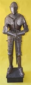 Rare 17th Century French Style Museum Quality Suit of Armor | An Authentic Life Size Italian Etch Full Suit of Plate Armor is decorated with embossed symbols including the French Fleur-de-lis | Likely made in the 18th Century | The armor is attached to a black base | The Suit of Armor includes an authentic period long sword typical of the European High Middle Ages (sometimes called knightly sword or arming sword) | The sword is a straight, double-edged weapon with a single-handed cruciform hilt measuring 47 inches | Dimensions: 70″ H (Tall) without base; 77″ H (Tall) with base x 19″ W at shoulders x 12 ” D at the feet | This suit of armor is complete with the following: a helmet – to protect the head a gorget (or bevor) – steel collar designed to protect the throat pauldrons – armor designed to protect the shoulder areas besagews – armor that protects the armpits (in this case a winged pauldron version) couters – plate armor designed to protect the elbow areas (in this case an articula