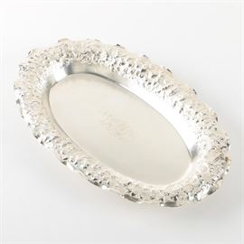 Antique 19th Century George W. Shiebler English Sterling Silver Serving Dish with a Floral Repousse Design | A rare George W. Shiebler & Co. Circa 1880 | This English Sterling oval dish has a wavy rim with a repousse floral design | The George W. Shiebler & Co. was founded in 1876, and went out of business in 1910. The base of the dish is marked “Sterling” and bears the Company’s “S” mark surrounded by wings with “The C B. Starr” written above. The piece has a personalized engraving and a total approximate weight of 13.605 ozt. 