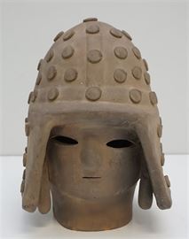 An Early 4th Century Japanese Haniwa warrior with helmet made from terracotta. Measures 10.5" H x 7" x 6.5";. Weight 6 pds. REF: Haniwa by Fumio Miki. The first and most common haniwa were barrel-shaped cylinders used to mark the borders of a burial ground. Later, in the early 4th century, the cylinders were surmounted by sculptural forms such as figures of warriors, female attendants, dancers, birds, animals, boats, military equipment, and even houses. It is believed that the figures symbolized continued service to the deceased in the other world. The eyes, noses, and mouths of the hollow forms are indicated by perforation, lending the objects a mysterious charm. 