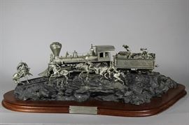 Important Pewter Sculpture Entitled "Attack on the Iron Horse" by American artist Michael Boyett | The sculpture depicts Native Americans attacking a moving locomotive being defended by a group of soldiers. The sculpture sits on a wooden base with a pewter plaque. Signed by the artist and dated 1988, with a foundry mark | Dimensions: 8" H x 25" W" x 13" D. Very Good condition. About the Artist: From the artist's website: Michael Boyett grew up in a military environment. His father, a career officer in the US Air Force, moved frequently across the US, exposing Michael and his family to much of the diverse history and romance of our country. As a child, using his vivid imagination, Michael began to draw imaginary scenes of frontier America and early recognition of his artistic talent encouraged him to explore various forms of art. Combining this growing talent with his natural love for his nation’s heritage and landscape, seemed to create an almost inseparable pathway for his career. Aft