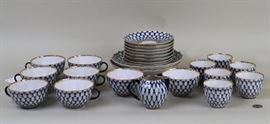 A Russian Lomonosov Porcelain Tea/Coffee Service in the traditional trademark cobalt net style | Hand Decorated Set Comprised of eight coffee cups and saucers, six tea bowls, a creamer and two bowls. The verso of each piece has the geniune Royal Lomonosov hallmark "Hand Decorated - LFZ - 1744 - St Petersburg Russia"| Measures - Largest: 8 1/2" diameter. Provenance: Previously Estate of David Niven.From the Royal factory of Lomonosov - The Russian Imperial Porcelain Manufactory. The hallmark on the bottom of each piece of Lomonosov looks like 'A' 'Q' 'B'. However, it's actually says in Cyrillic 'L' 'F' 'Z' which stands for "Lomonosov Farfor Zavod" - meaning "Lomonosov Porcelain Factory". The Russian Imperial Porcelain Factory was set up by the Russsian royal family exclusively for its use. 
