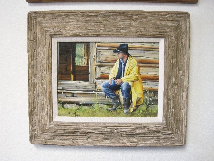 
1992 Oil on canvas painting of a cowboy wearing a yellow slicker seated by the doorway of a log cabin, by Vic Schendel (Fort Collins, Colorado). 9" x 12" in a 15" x 18" frame